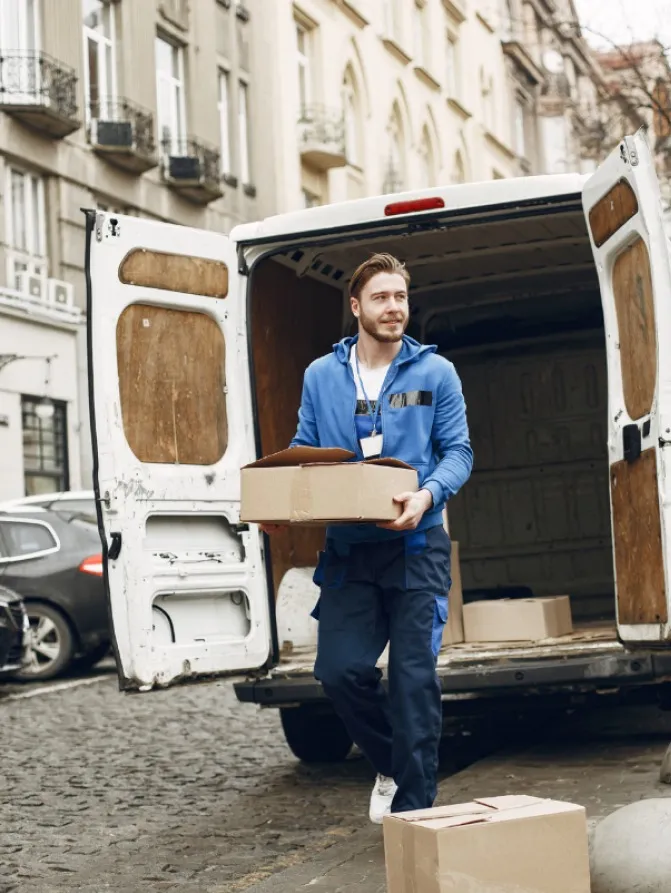 Mitarbeiter lädt Pakete aus einem Transporter